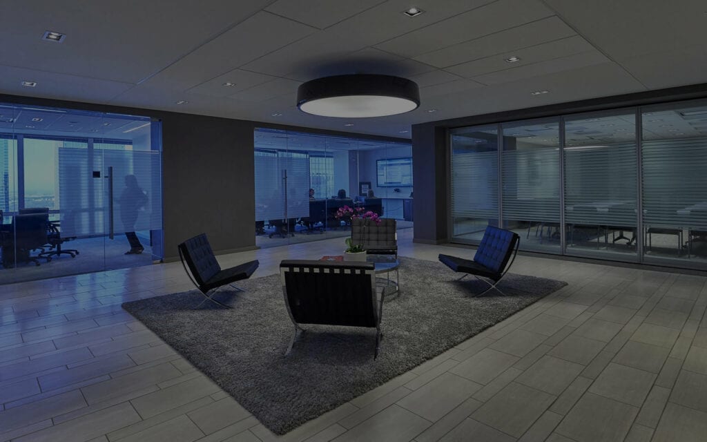 Modern office lounge with sleek chairs and city views at dusk.